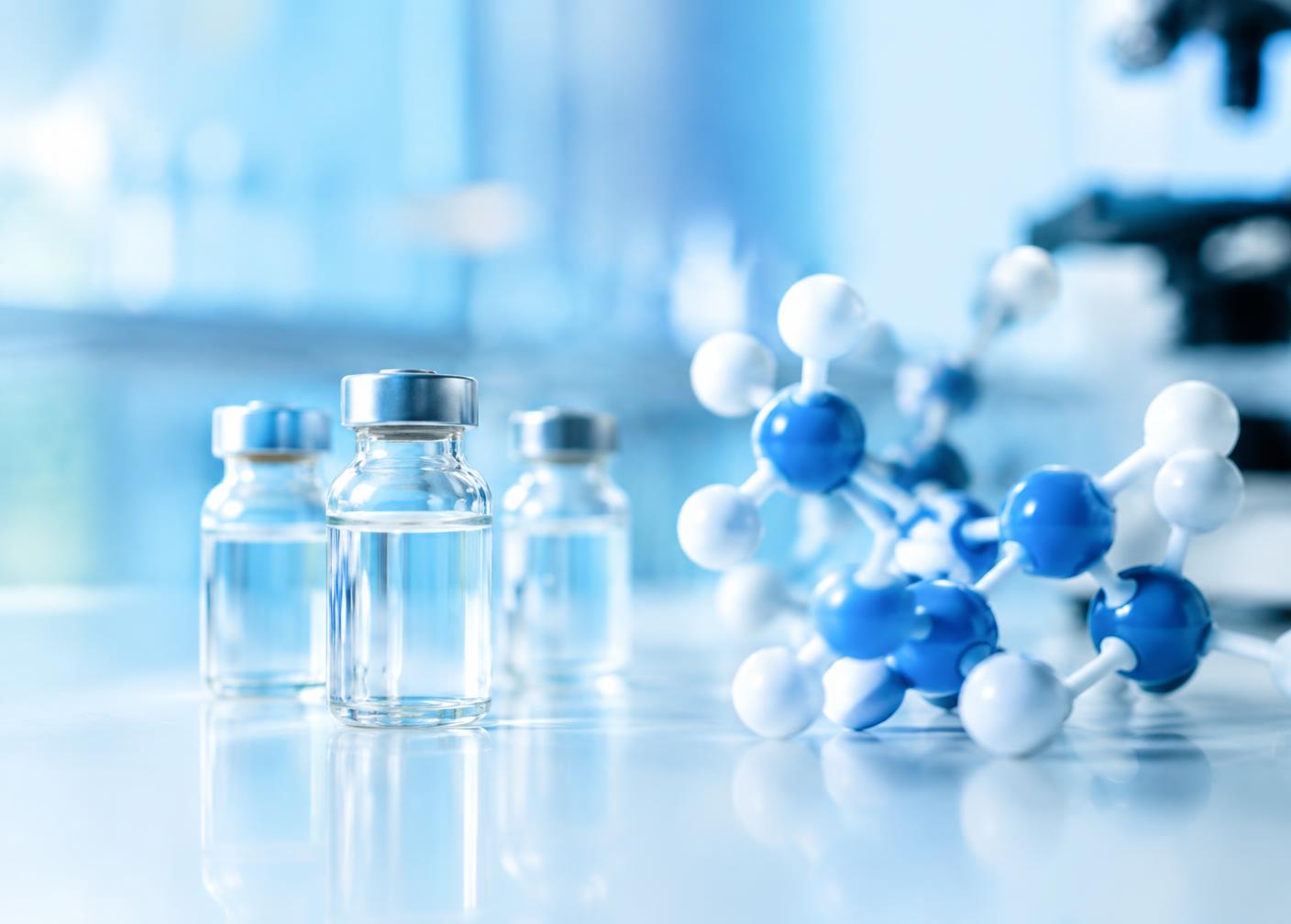 Glass vials and a molecular model in a bright laboratory